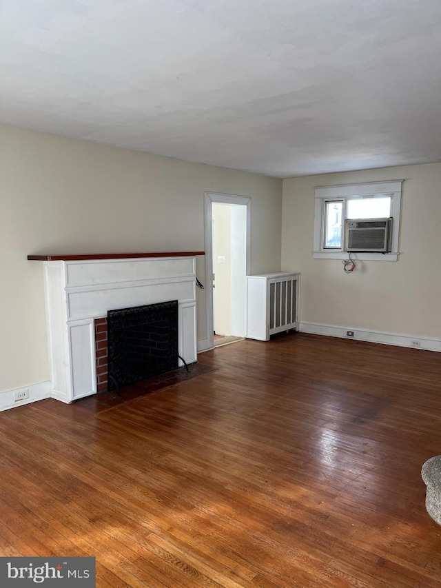 unfurnished living room featuring cooling unit and dark hardwood / wood-style floors