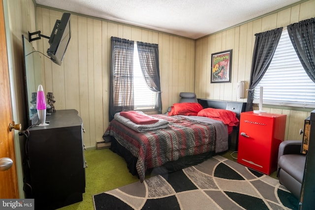 carpeted bedroom featuring wooden walls and a textured ceiling