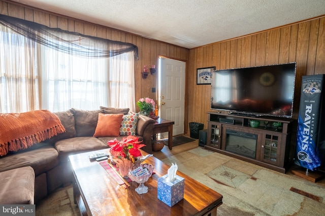 living room featuring carpet flooring, a textured ceiling, and wood walls