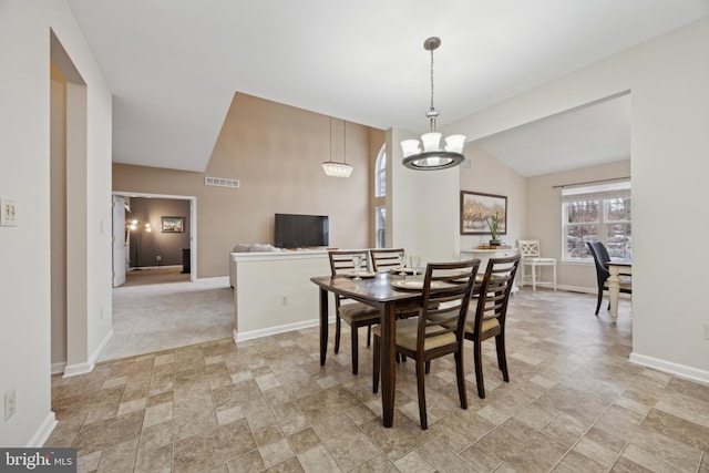 dining space with an inviting chandelier and lofted ceiling