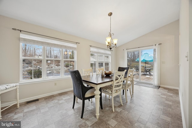 dining room featuring plenty of natural light, lofted ceiling, and a notable chandelier