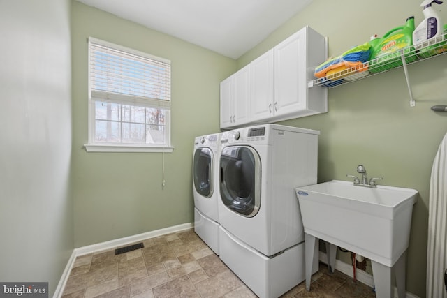 washroom with washing machine and dryer, sink, and cabinets