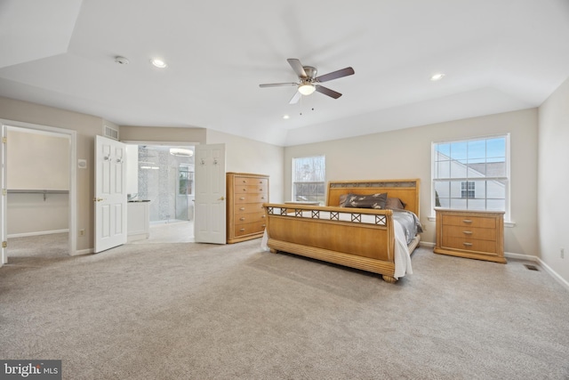 carpeted bedroom featuring a walk in closet, vaulted ceiling, ceiling fan, connected bathroom, and a closet