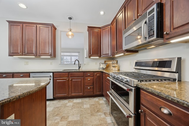 kitchen featuring decorative light fixtures, sink, stainless steel appliances, and dark stone counters