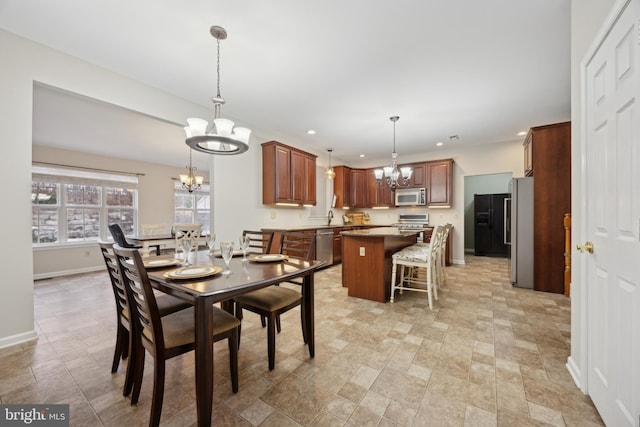 dining space with sink and a chandelier