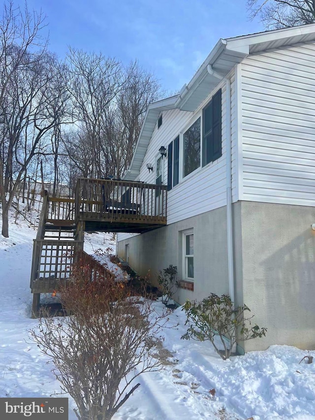 view of snow covered exterior with a deck