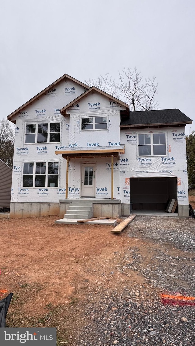 unfinished property featuring a garage and driveway