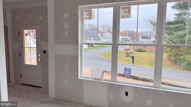 doorway with a residential view and unfinished concrete flooring