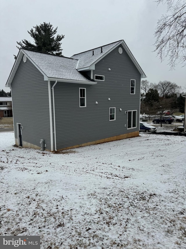 view of snow covered rear of property