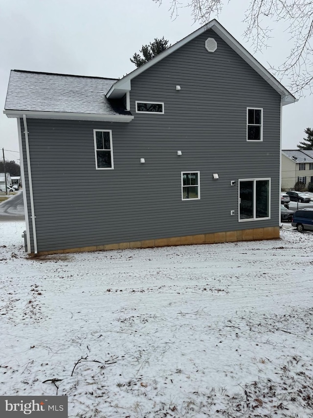 view of snow covered rear of property