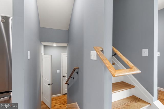 staircase with baseboards and wood finished floors