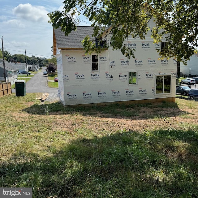 view of side of home with roof with shingles