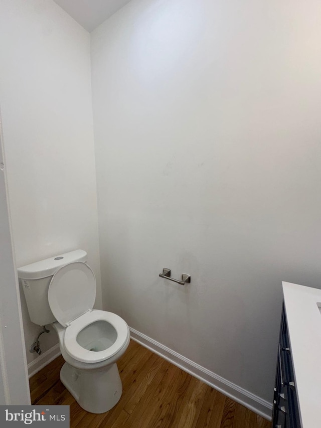 bathroom with wood-type flooring, vanity, and toilet