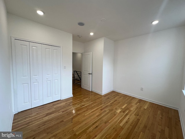 unfurnished bedroom with dark wood-type flooring and a closet