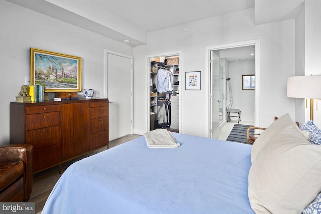 bedroom with a walk in closet, dark wood-type flooring, and a closet