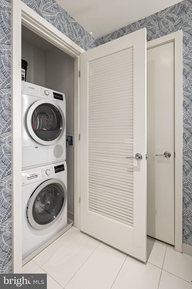 washroom with light tile patterned flooring and stacked washer and clothes dryer