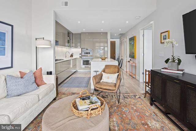 living room with sink and light hardwood / wood-style flooring