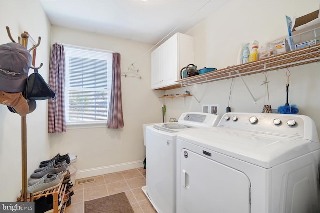 laundry area with cabinets, washer and clothes dryer, and light tile patterned floors