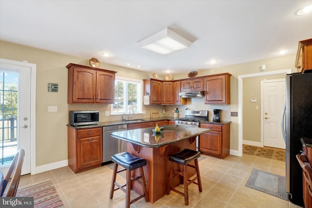 kitchen featuring a kitchen island, appliances with stainless steel finishes, tasteful backsplash, sink, and a kitchen breakfast bar