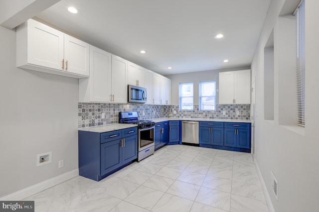 kitchen with white cabinets, backsplash, stainless steel appliances, and blue cabinets