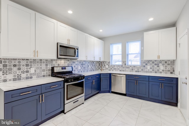 kitchen with blue cabinetry, white cabinetry, stainless steel appliances, and tasteful backsplash