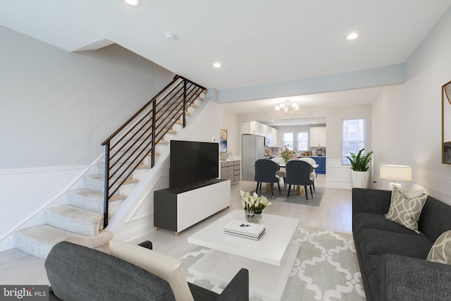 living room featuring an inviting chandelier and light hardwood / wood-style flooring