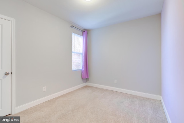 spare room featuring light colored carpet