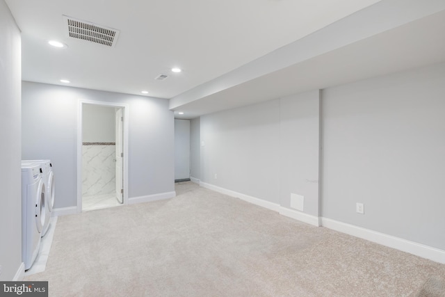 basement with light carpet and washer and clothes dryer