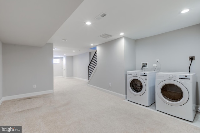 laundry area featuring light colored carpet and washing machine and clothes dryer