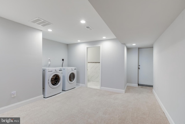 laundry area with washing machine and clothes dryer and light carpet