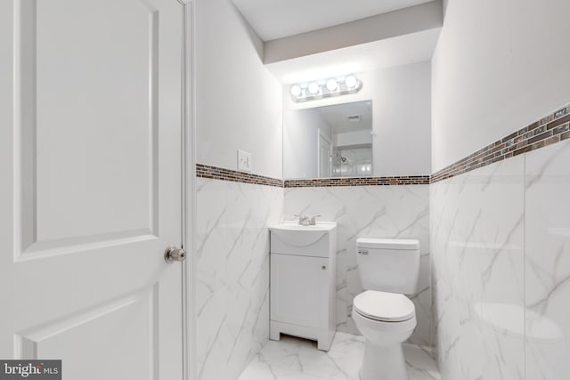 bathroom with walk in shower, vanity, and toilet