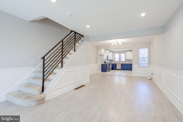 stairway featuring a chandelier and wood-type flooring