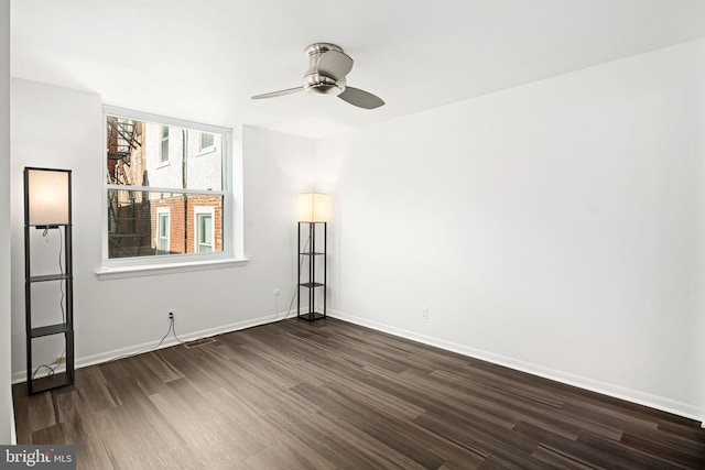 spare room with ceiling fan and dark wood-type flooring