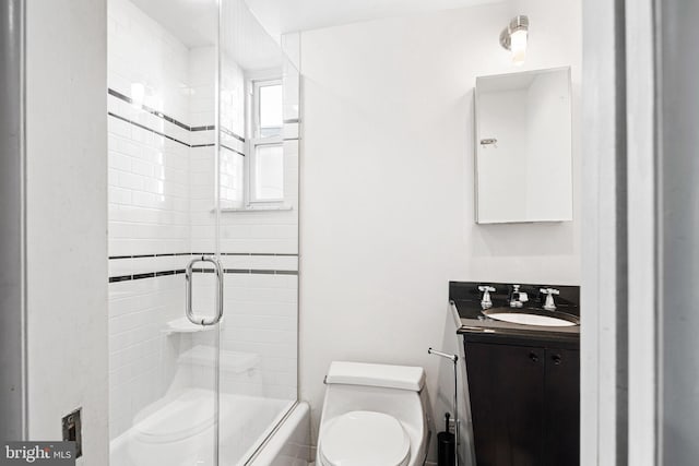 full bathroom featuring vanity, bath / shower combo with glass door, and toilet