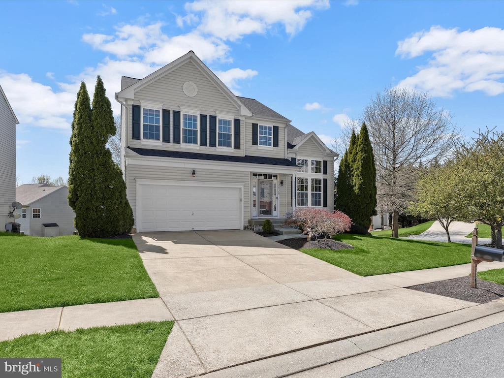 traditional home with driveway, a front lawn, and an attached garage