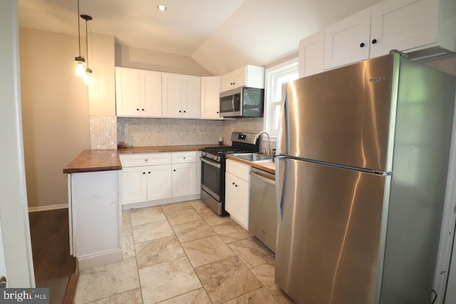 kitchen with stainless steel appliances, sink, pendant lighting, white cabinets, and butcher block counters