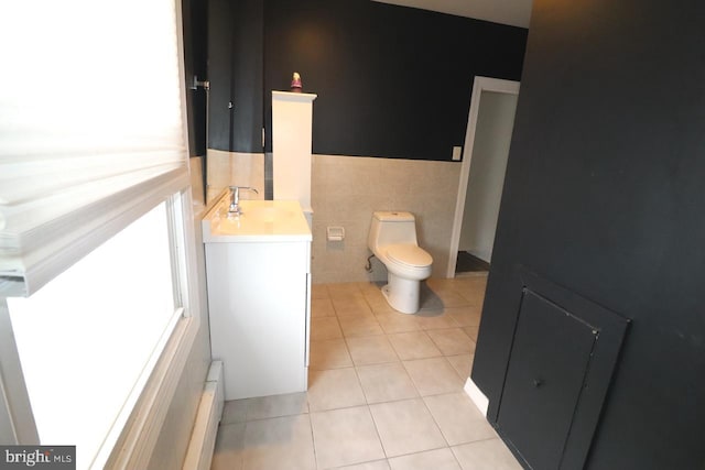 bathroom featuring vanity, tile patterned floors, toilet, baseboard heating, and tile walls