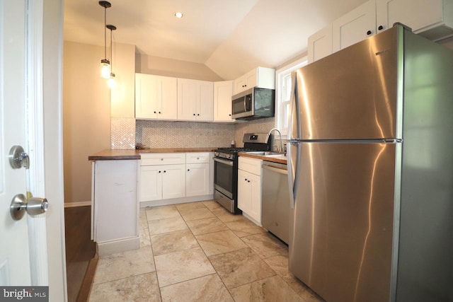 kitchen with decorative light fixtures, white cabinetry, stainless steel appliances, and tasteful backsplash