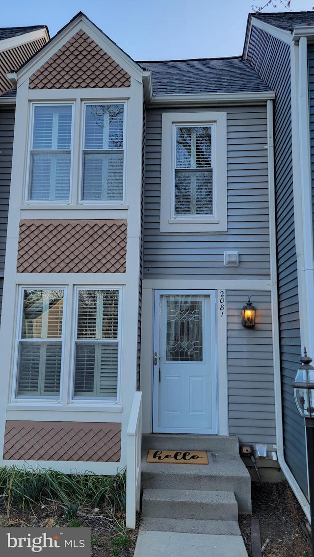 property entrance with a shingled roof