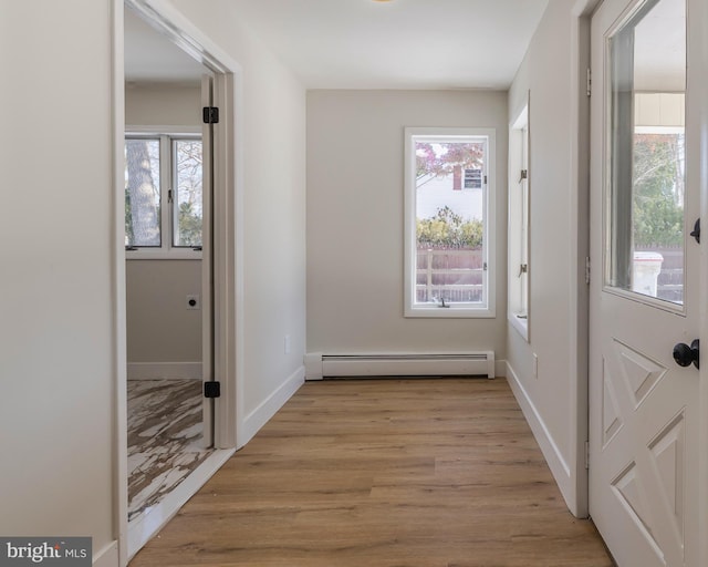 doorway featuring baseboard heating and light hardwood / wood-style flooring