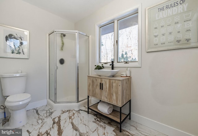 bathroom with vanity, toilet, and a shower with door