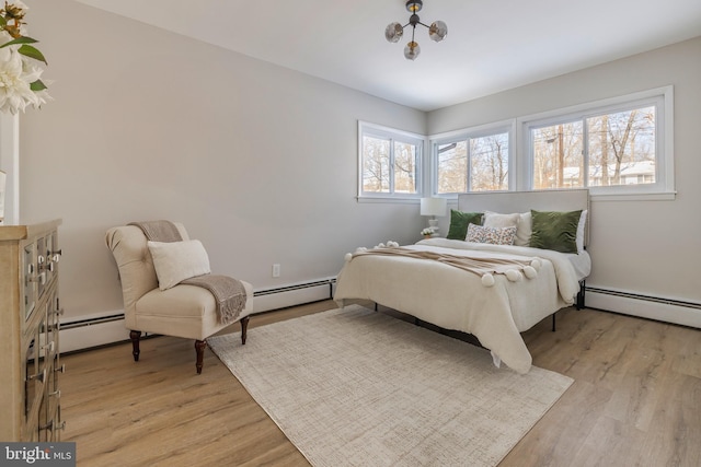 bedroom with baseboard heating and light wood-type flooring