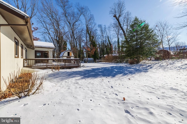 snowy yard featuring a wooden deck