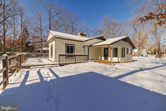 snow covered house featuring a deck