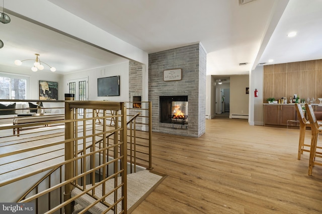 interior space with baseboard heating, a chandelier, and light hardwood / wood-style floors