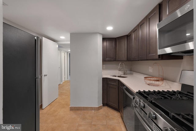 kitchen with stainless steel appliances, sink, dark brown cabinets, and light tile patterned floors