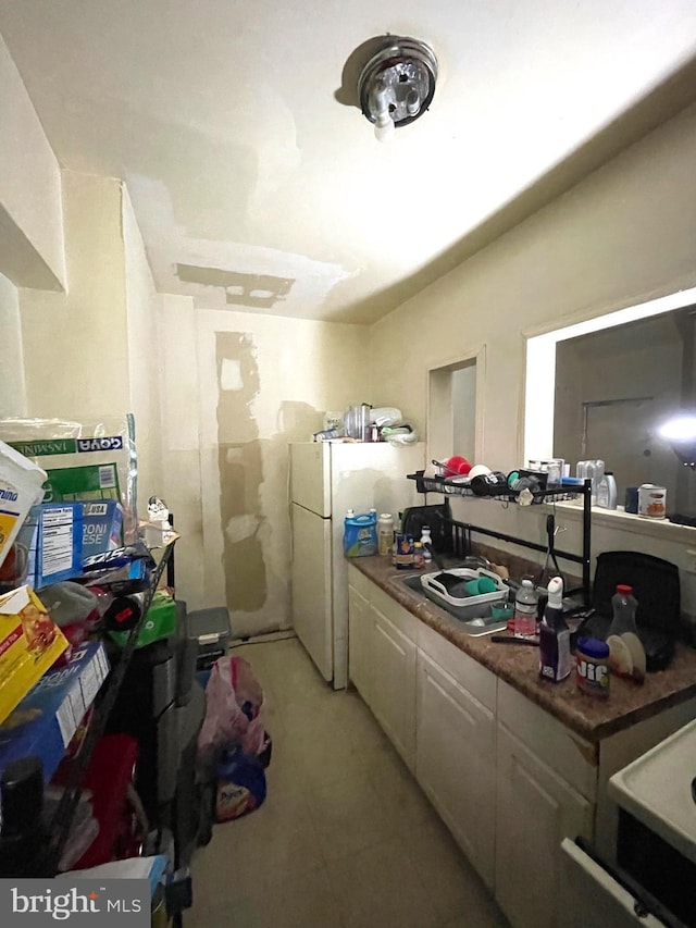 kitchen with white cabinetry and white fridge