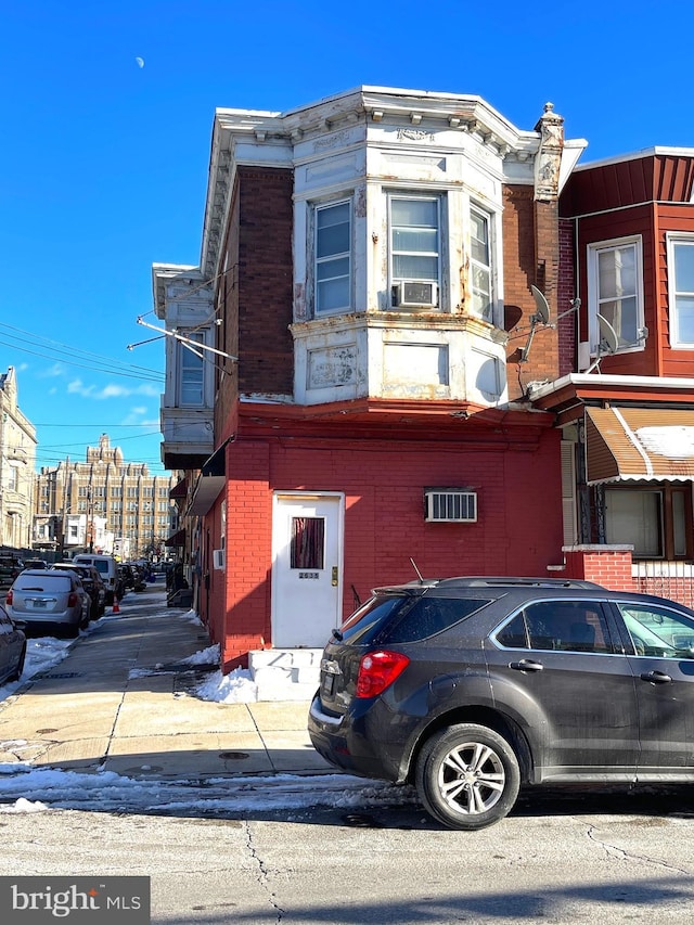 view of front facade featuring brick siding and cooling unit