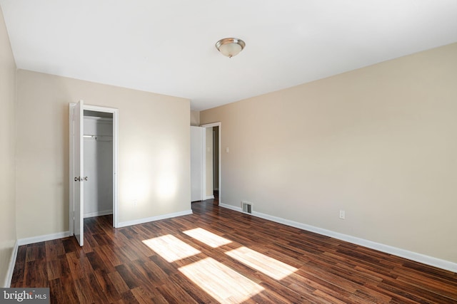 unfurnished bedroom featuring dark hardwood / wood-style floors and a closet