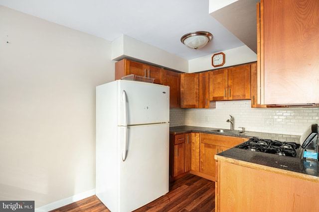 kitchen featuring backsplash, dark hardwood / wood-style flooring, sink, and white fridge